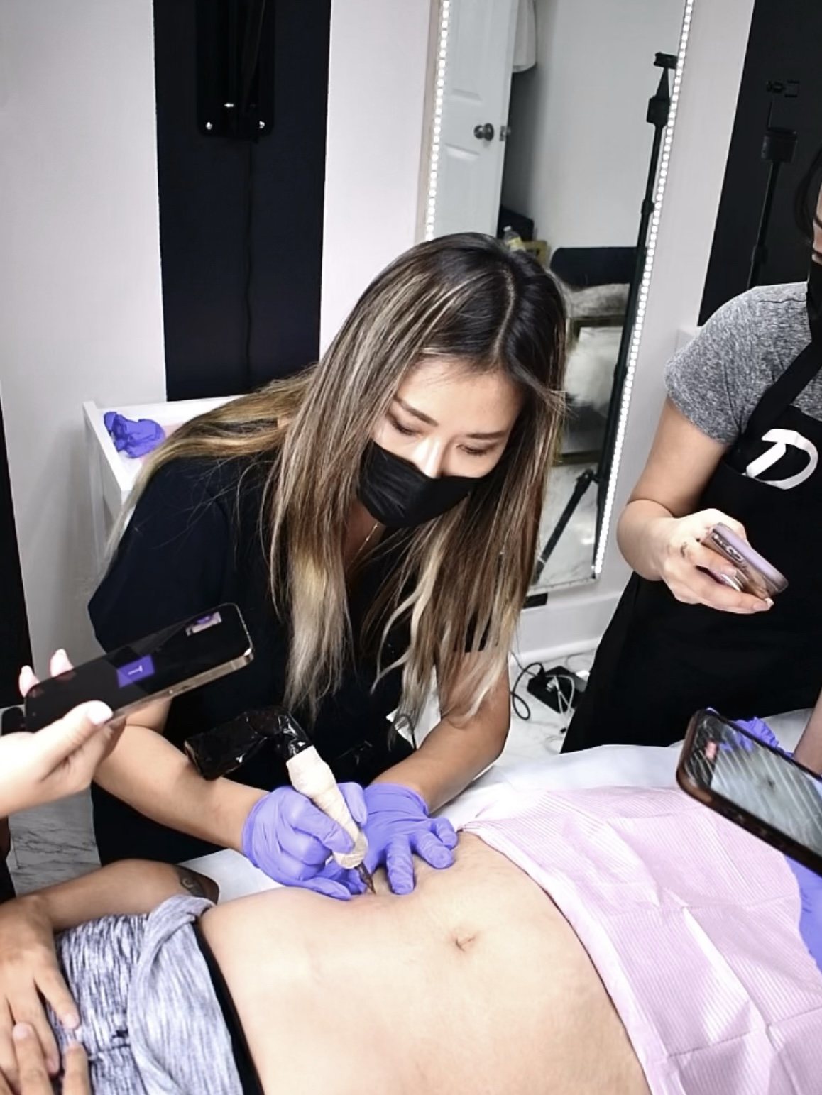Gina Lee working on a client during a camouflage tattoo session